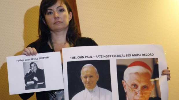 Joelle Casteix, víctima de abuso sexual, muestra la foto del padre estadounidense Lawrence Murphy, acusado de haber abusado de 200 niños sordos; y de los papas Juan Pablo II y Benedicto XVI. (Foto: Reuters).