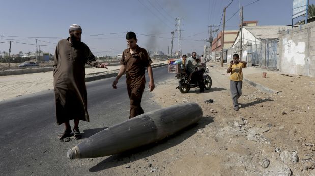 Palestinos observan un misil israelí. (Foto: AP)