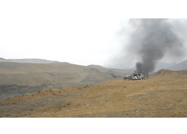 Desolación. Un auto arde en medio de un basural en el desierto. (Foto: Galería 80m2)