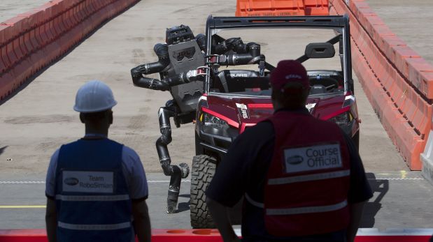 Robot a punto de caer del vehículo que conduce durante la prueba. (Foto: DAVID MCNEW/REUTERS)