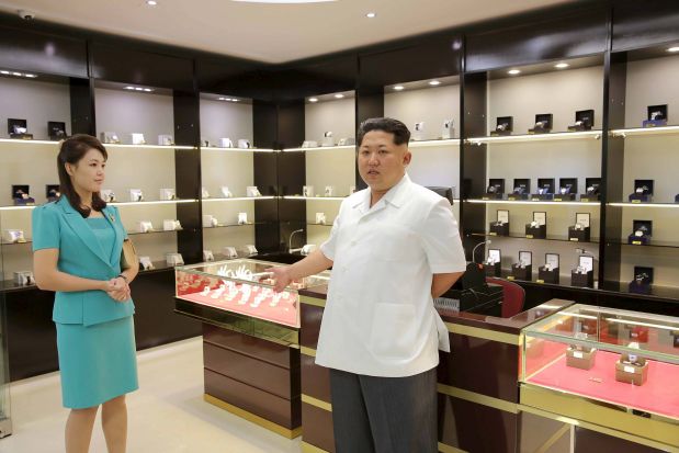 North Korean leader Kim Jong Un speaks next to his wife Ri Sol Ju (3rd L) as he gives field guidance at the new terminal of Pyongyang International Airport in this undated photo released by North Korea's Korean Central News Agency (KCNA) on June 25, 2015. Designer shirts, duty free watches and cosmetics, and chocolate fondue will soon await visitors to North Korea, according to photos of Pyongyang's new airport terminal released by state media on Thursday. Three pages of Thursday's ruling Workers' Party official daily newspaper, the Rodong Sinmun, were devoted to images of leader Kim and his wife inspecting shops, restaurants and waiting areas in a large, glass-fronted terminal building state media said would open on July 1.    REUTERS/KCNA ATTENTION EDITORS - THIS PICTURE WAS PROVIDED BY A THIRD PARTY. REUTERS IS UNABLE TO INDEPENDENTLY VERIFY THE AUTHENTICITY, CONTENT, LOCATION OR DATE OF THIS IMAGE. FOR EDITORIAL USE ONLY. NOT FOR SALE FOR MARKETING OR ADVERTISING CAMPAIGNS. THIS PICTURE IS DISTRIBUTED EXACTLY AS RECEIVED BY REUTERS, AS A SERVICE TO CLIENTS. NO THIRD PARTY SALES. SOUTH KOREA OUT. NO COMMERCIAL OR EDITORIAL SALES IN SOUTH KOREA.