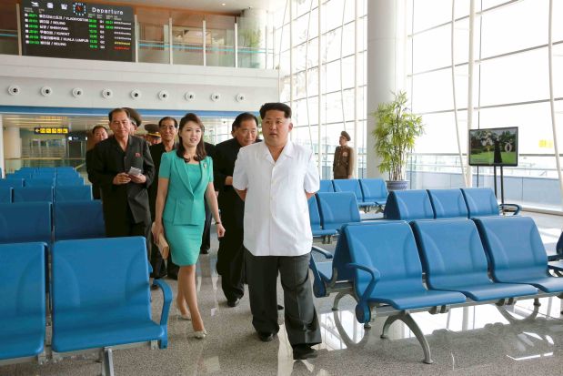 North Korean leader Kim Jong Un (front) walks with his wife Ri Sol Ju as he gives field guidance at the new terminal of Pyongyang International Airport in this undated photo released by North Korea's Korean Central News Agency (KCNA) on June 25, 2015. Designer shirts, duty free watches and cosmetics, and chocolate fondue will soon await visitors to North Korea, according to photos of Pyongyang's new airport terminal released by state media on Thursday. Three pages of Thursday's ruling Workers' Party official daily newspaper, the Rodong Sinmun, were devoted to images of leader Kim and his wife inspecting shops, restaurants and waiting areas in a large, glass-fronted terminal building state media said would open on July 1.    REUTERS/KCNA ATTENTION EDITORS - THIS PICTURE WAS PROVIDED BY A THIRD PARTY. REUTERS IS UNABLE TO INDEPENDENTLY VERIFY THE AUTHENTICITY, CONTENT, LOCATION OR DATE OF THIS IMAGE. FOR EDITORIAL USE ONLY. NOT FOR SALE FOR MARKETING OR ADVERTISING CAMPAIGNS. THIS PICTURE IS DISTRIBUTED EXACTLY AS RECEIVED BY REUTERS, AS A SERVICE TO CLIENTS. NO THIRD PARTY SALES. SOUTH KOREA OUT. NO COMMERCIAL OR EDITORIAL SALES IN SOUTH KOREA.