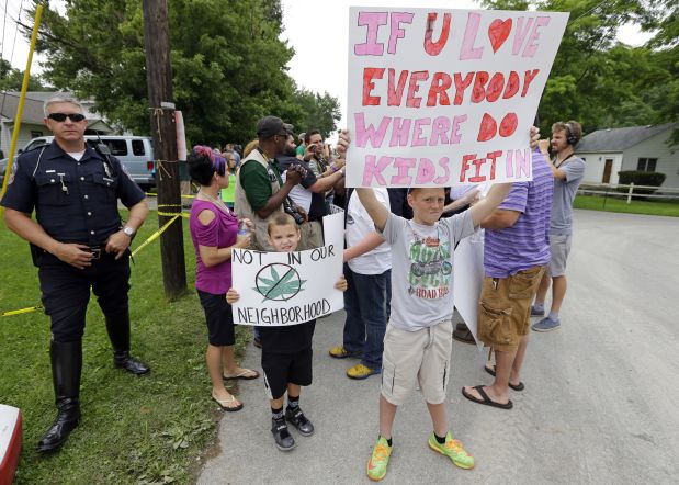 Protesters gather across the street from the First Church of Cannabis during the church's first service, Wednesday, July 1, 2015, in Indianapolis. Church Founder Bill Levin said he decided to keep marijuana out of Wednesday's service to ensure he can test the Indiana religious objections law in civil court instead of on criminal grounds. (AP Photo/Michael Conroy)