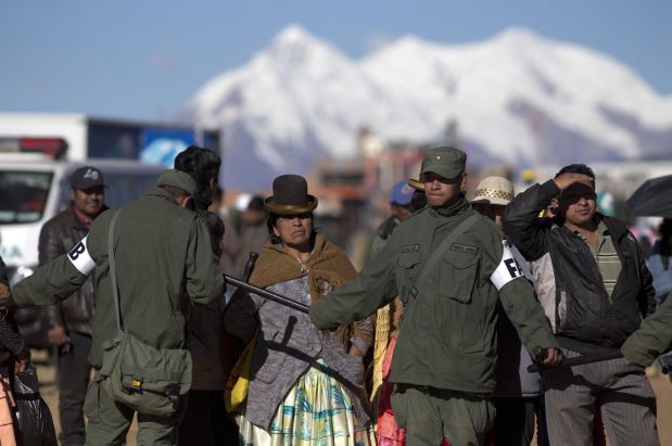 Soldiers create a perimeter which people waiting to see Pope Francis cannot cross, before the pontiff's arrival to El Alto International airport in El Alto, Bolivia, Wednesday, July 8, 2015. Due to the altitude, the pope will spend only a few hours in the capital city La Paz, located near El Alto, during his South American tour. (AP Photo/Eduardo Verdugo)