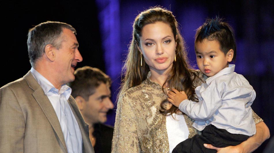 U.S. movie star Robert De Niro, left, and U.S. actress Angelina Jolie, cradling her son Maddox, arrive to St. Mark's Square in Venice for the screening of their latest movie 