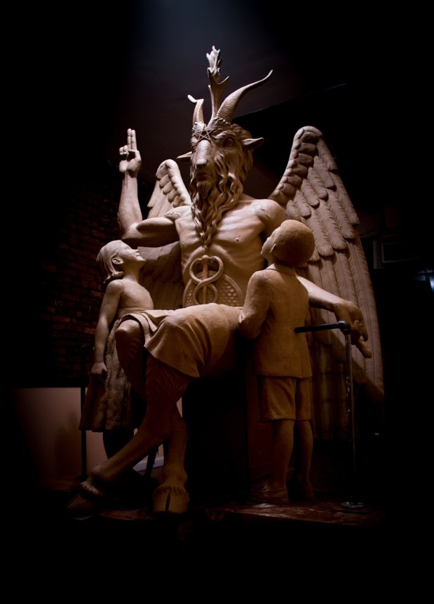 This 2014 photo provided by The Satanic Temple shows a bronze Baphomet, which depicts Satan as a goat-headed figure surrounded by two children. The Satanic Temple, a group advocating the separation of church and state, is considering proposing that the statue be placed outside the Arkansas Statehouse after their first choice of the Oklahoma Capitol grounds was scuttled in 2015 by a state Supreme Court ruling barring all religious monuments. (The Satanic Temple via AP)