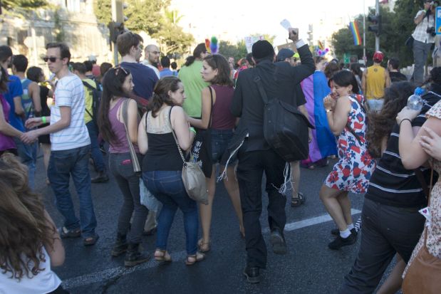 An ultra-Orthodox Jew attacks people with a knife during a Gay Pride parade Thursday, July 30, 2015 in central Jerusalem, Israel. Israeli police said several people were stabbed. (AP Photo/Sebastian Scheiner)