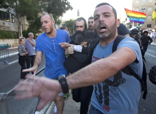 Plainclothes Israeli police detain an-ultra Orthodox Jew after he attacked people with a knife during a Gay Pride parade Thursday, July 30, 2015 in central Jerusalem. Israeli police said several people were stabbed. (AP Photo/Sebastian Scheiner)