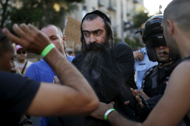 People detain after disarming an Orthodox Jewish assailant, after he stabbed and injured six participants of an annual gay pride parade in Jerusalem on Thursday, police and witnesses said July 30, 2015. REUTERS/Amir Cohen