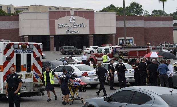 Dozens of law enforcement and emergency responders work in the parking lot after a suspect wielding a hatchet and gun inside a Nashville-area movie theater died after exchanging gunshots with SWAT team members that stormed the theater, police said, Wednesday, Aug. 5, 2015. The suspect, who was not identified, was armed with a gun and hatchet at the Carmike Hickory 8 theater in Antioch, said Don Aaron, a spoke, man for Metro Nashville police. (AP Photo/Mark Zaleski)