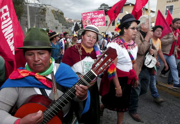 Protesters march in Quito, Ecuador, August 12, 2015. Ecuadorean Indigenous from the Confederation of Indigenous Nationalities of Ecuador (CONAIE) are arriving in Quito to participate in a nation-wide strike on August 13 against the government of Ecuador's President Rafael Correa, according to local media. The sign in the back reads 