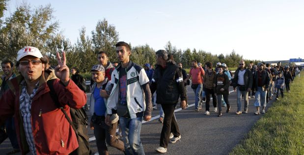 A group of migrants walks against the traffic on a motorway leading to Budapest as they left a transit camp in the village of Roszke, Hungary, September 7, 2015. Police used pepper spray on a crowd of migrants attempting to break through a cordon at Roszke, on Hungary's border with Serbia, on Monday, a Reuters witness said.        REUTERS/Marko Djurica