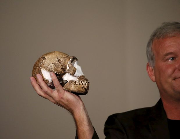 Professor Lee Berger holds a replica of the skull of a newly discovered ancient species, named 