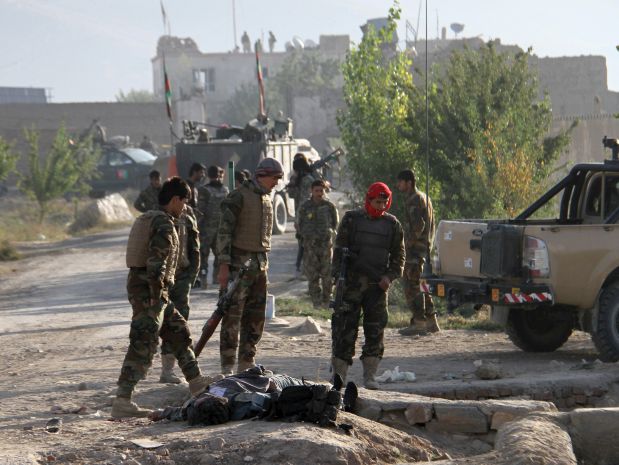 ATTENTION EDITORS - VISUAL COVERAGE OF SCENES OF DEATH OR INJURYAfghan National Army (ANA) soldiers stand over the body of a Taliban insurgent outside a prison in Ghazni, Afghanistan, September 14, 2015. Taliban insurgents stormed a prison in the central Afghan city of Ghazni early on Monday, killing police and releasing hundreds of prisoners, police said.  REUTERS/Stringer TEMPLATE OUT