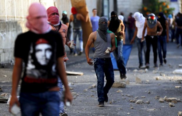 Palestinian stone-throwers take part in clashes with Israeli police in Shuafat, an Arab suburb of Jerusalem October 5, 2015. A Palestinian teenager was killed on Monday in a clash with Israeli soldiers near the West Bank town of Bethlehem, a Palestinian hospital source said. Violence in the Israeli-occupied West Bank and Jerusalem has intensified in the past few weeks and the teenager's reported death was the latest in a series of incidents that has raised fears of wider escalation. REUTERS/Ammar Awad