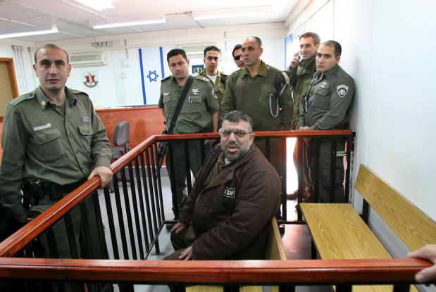Sheikh Hassan Youssef (C), a senior Hamas leader in the West Bank then imprisoned in Israel, is surrounded by Israeli border police officers during a hearing in the Ofer military court near the West Bank city of Ramallah in this January 22, 2006 file photo. Early on October 20, 2015, Israeli forces detained Youssef, a top leader of the Hamas Islamist group in the West Bank. 