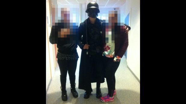 This picture made available to AFP by a student shows the masked man armed with a sword posing for a photo with two other students before attacking students and staff at the primary and middle school in Trollhattan, southwestern Sweden, on October 22, 2015. The man brandishing a sword broke into a school in Sweden, killing two people and seriously wounding two others before being shot by police.  AFP PHOTO  +++ RESTRICTED TO EDITORIAL USE