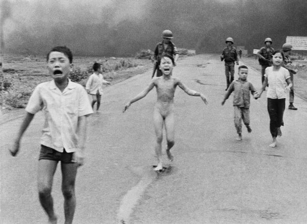 FILE - In this June 8, 1972, file photo, 9-year-old Kim Phuc, center, runs with her brothers and cousins, followed by South Vietnamese forces, down Route 1 near Trang Bang after a South Vietnamese plane accidentally dropped its flaming napalm on its own troops and civilians. The terrified girl had ripped off her burning clothes while fleeing. In late September 2015, Phuc, 52, began a series of laser treatments at the Miami Dermatology and Laser Institute to smooth and soften the pale, thick scar tissue that she has endured for more than 40 years. (AP Photo/Nick Ut, File)