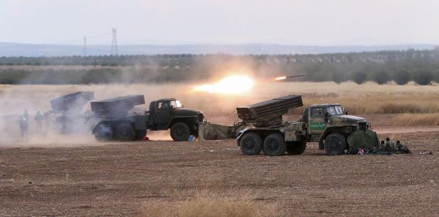 In this photo taken on Wednesday, Oct.  7, 2015, Syrian army rocket launchers fire near the village of Morek in Syria. The Syrian army has launched an offensive this week in central and northwestern Syria aided by Russian airstrikes. (AP Photo/Alexander Kots, Komsomolskaya Pravda, Photo via AP)