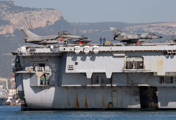 Rafale , left, and Super-Etendard jetfighters are on the deck of France's nuclear-powered aircraft carrier Charles de Gaulle as it leaves its home port of Toulon, southern France, Wednesday, Nov.18, 2015. France has decided to deploy its aircraft carrier in the eastern Mediterranean sea for fighting Islamic State group.(AP Photo/Claude paris)