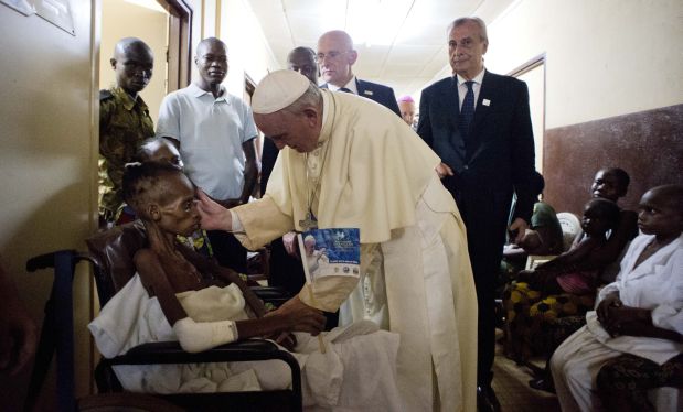 Pope Francis comforts a child during a brief, unscheduled stop at a pediatric hospital on his way to Bangui cathedral, Central African Republic, Sunday, Nov. 29, 2015. Pope Francis is in Africa for a six-day visit that is taking him to Kenya, Uganda and the Central African Republic.(L'Osservatore Romano/Pool Photo via AP)