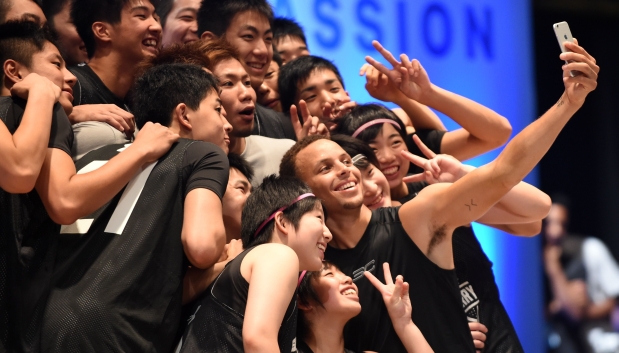TOPSHOTSNational Basketball Association (NBA) Golden State Warriors 2014-2015 season MVP Stephen Curry takes a selfie with Japan's Under-18 players during a basketball clinic in Tokyo on September 4, 2015. Curry started his three-nation (Japan, China and Philippines) Under Armour Asia tour to promote the company's limited basketball shoes, 