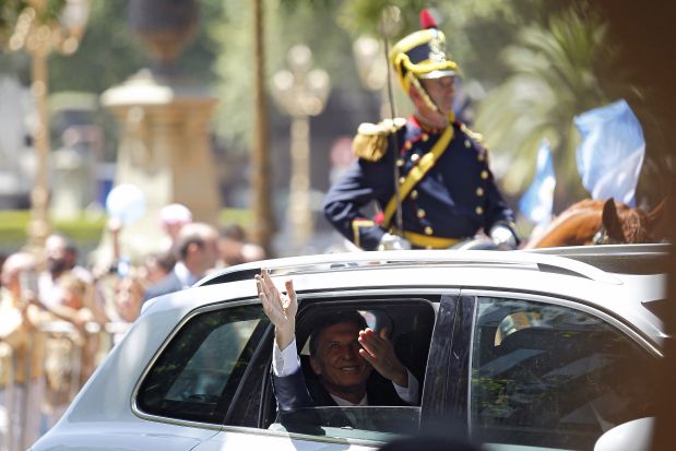 Argentine President-elect Mauricio Macri waves on his way to the Congress in Buenos Aires on December 10, 2015 to attend the inauguration of his term. Macri's inauguration marks the start of a new era for Argentina: a tilt to the right after 12 years under Kirchner and her late husband Nestor, the left-wing power couple that led the country back to stability after an economic meltdown in 2001. AFP PHOTO/EMILIANO LASALVIA