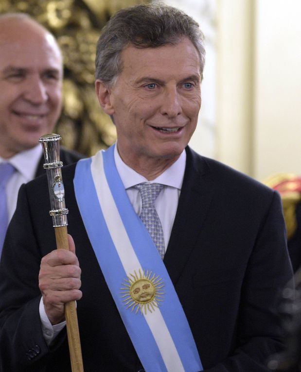 Argentine President Mauricio Macri, already wearing the presidential sash and staff, poses during his inauguration at the Casa Rosada government palace in Buenos Aires on December 10, 2015. Macri's inauguration marks the start of a new era for Argentina: a tilt to the right after 12 years under Kirchner and her late husband Nestor, the left-wing power couple that led the country back to stability after an economic meltdown in 2001.   AFP PHOTO/JUAN MABROMATA