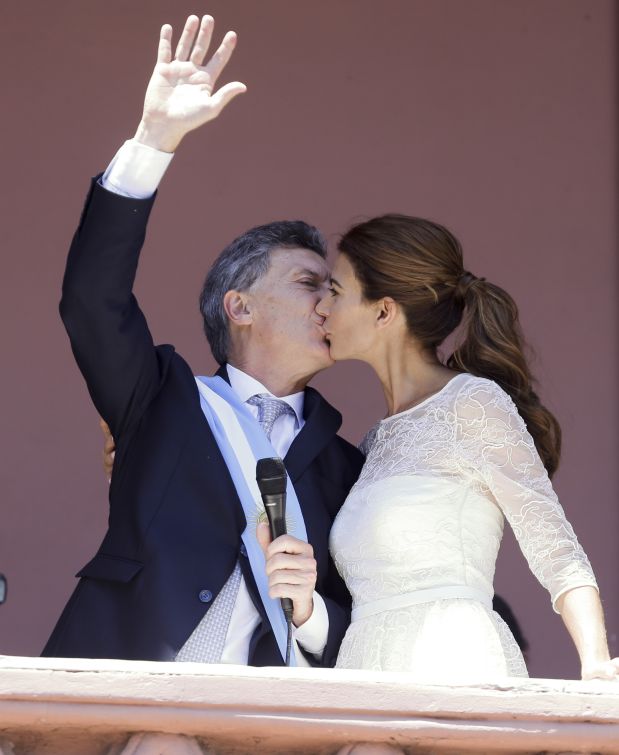 Argentina's President Mauricio Macri, left, kisses First Lady Juliana Awada, from the balcony at the government house in Buenos Aires, Argentina,  Thursday, Dec. 10, 2015. Macri promises to usher in an era of more civil discourse and roll back much of the Fernandez administration spending that many economists say has brought Argentina to the brink of another financial crisis. (AP Photo/Victor R. Caivano)