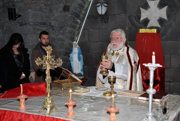 A priest leads Christmas mass at a Syriac Orthodox church in the Christian Hamidiyeh neighbourhood of Syria's central city of Homs on December 24, 2015. AFP PHOTO / STR