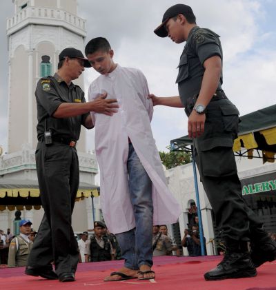 A young Acehnese man arrives to be caned in public, a punishment under the Islamic sharia law, under the offence of 