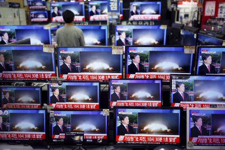 A sales assistant watches TV sets broadcasting a news report on North Korea's nuclear test, in Seoul, January 6, 2016. REUTERS/Kim Hong-Ji