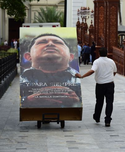 National Assembly employees remove from the building  pictures of late President Hugo Chavez, in Caracas on January 6, 2016. Venezuela's opposition on Tuesday broke the government's 17-year grip on the legislature and vowed to force out President Nicolas Maduro despite failing for the time being to clinch its hoped-for 