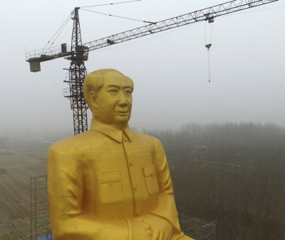 In this Monday, Jan. 4, 2016 photo, scaffolding partially surrounds a 36.6-meter (120-foot) tall gold-colored statue of former Chinese leader Chairman Mao Zedong in Tongxu County in central China's Henan province. According to Chinese state media, businessmen and local villagers contributed nearly 3 million yuan (7,000) to build the cement statue. (Chinatopix via AP) CHINA OUT