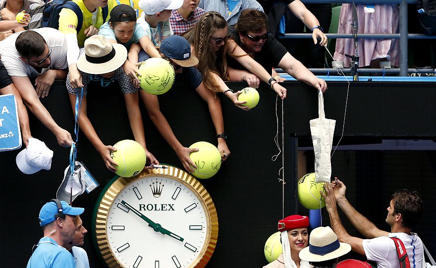 Roger Federer of Switzerland signs autographs after defeating Alexandr Dolgopolov of Ukraine in their second round match at the Australian Open tennis championships in Melbourne, Australia, Wednesday, Jan. 20, 2016.(AP Photo/Vincent Thian)