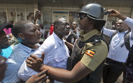 FILE - In this Monday, Feb. 15, 2016 file photo, leading opposition leader and presidential candidate Kizza Besigye, center, is grabbed before being arrested by riot police in downtown Kampala, Uganda. An aide said Besigye had been arrested again on election day, late Thursday, Feb. 18, 2016, in the Kampala suburb of Naguru, where he had gone to investigate alleged ballot stuffing. (AP Photo/Ben Curtis, File)