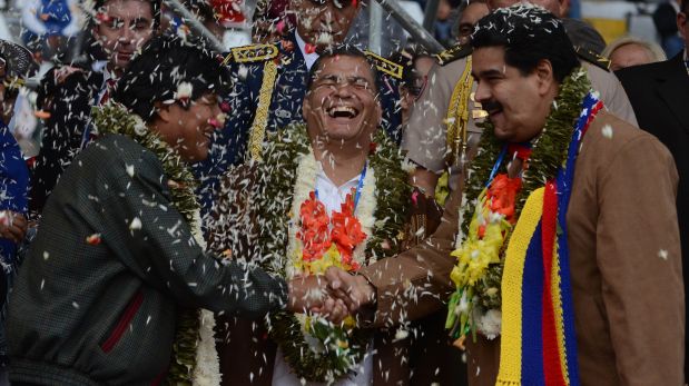 Bolivia's President Evo Morales, left, and Venezuela's President Nicolas Maduro, right, shake hands as Ecuador's President Rafael Correa, center, laughs during the welcoming ceremony for delegates of the G77 + China Summit in Santa Cruz, Bolivia, Saturday, June 14, 2014. (AP Photo)
