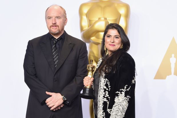 HOLLYWOOD, CA - FEBRUARY 28: Actor Louis C.K. (L) and filmmaker Sharmeen Obaid-Chinoy winner of the Best Documentary Short Subject award for 'A Girl in the River: The Price of Forgiveness' pose in the press room during the 88th Annual Academy Awards at Loews Hollywood Hotel on February 28, 2016 in Hollywood, California.   Jason Merritt/Getty Images/AFP== FOR NEWSPAPERS, INTERNET, TELCOS & TELEVISION USE ONLY ==