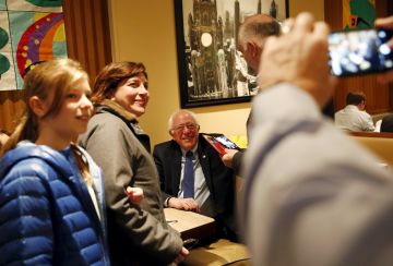 U.S. Democratic presidential candidate Bernie Sanders smiles as people take photos after sitting down for breakfast at Lou Mitchell's restaurant and bakery in Chicago, Illinois March 15, 2016. REUTERS/Shannon Stapleton