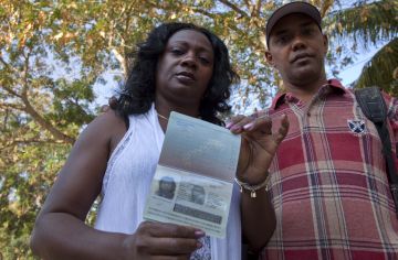 Berta Soler, leader of Cuban dissident group Ladies in White, poses with her new passport, standing next to her husband Angel Moya, in Havana, Cuba, Friday, Feb. 8, 2013. Soler, the most prominent member of the dissident group, picked up her new passport in the morning and said she plans to make a long-delayed trip to Europe to pick up the EU's Sakharov award, something she has been unable to do until now because she was denied an exit visa. (AP Photo/Ramon Espinosa)