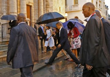 U.S. President Barack Obama steps over a puddle while touring Old Havana with his family, in Havana March 20, 2016.  REUTERS/Carlos Barria
