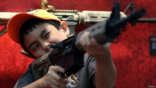 Un niño sostiene un arma durante la convención anual de la Asociación Nacional del Rifle de Estados Unidos.