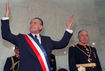 FILE - New Chilean President Patricio Aylwin (L) gestures on March 11, 1990 in Valparaiso, Chile, after receiving the presidential sash during inaugural ceremonies, as outgoing President Augusto Pinochet (R) looks on.  Patricio Aylwin, the first president of Chile after its return to democratic rule following Pinochet's dictatorship, died on April 19, 2016 at the age of 97. / AFP / STR