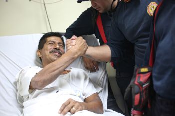 Pablo Rafael Cordova Ca?izares shakes hands with one of the Colombian firefighters who rescued him, at the Verdi Cevallos Balda hospital in Portoviejo, Ecuador, Monday, April 18, 2016. The 51-year-old hotel administrator was one of a trickle of survivors pulled from the rubble after Ecuador's strongest earthquake in decades flattened towns along the coast and killed hundreds. (AP Photo/Emilio D. Garcia)