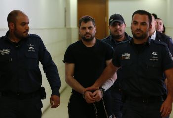 Israeli Yosef Haim Ben-David (C), the ringleader in the killing of Palestinian teenager Mohammed Abu Khdeir last year, is escorted by Israeli policemen at the district court in Jerusalem in May 3, 2016.  Israeli prosecutors demanded a life sentence for a Jewish man found to be the ringleader of a group that beat and burned alive the Palestinian teenager in 2014. / AFP / AHMAD GHARABLI
