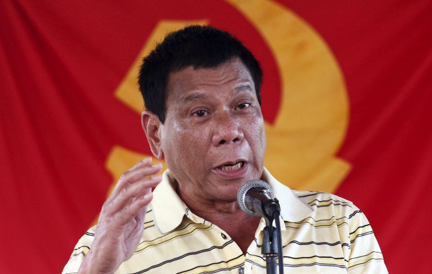 Presidential candidate Mayor Rodrigo Duterte speaks in front of a communist rebel group New People's Army (NPA) flag during the release of five policemen held by the rebels for a week, in Davao city, southern Philippines, April 25, 2016. REUTERS/Keith Bacongco/File Photo         SEARCH ?DUTERTE PRESIDENCY? FOR ALL IMAGES