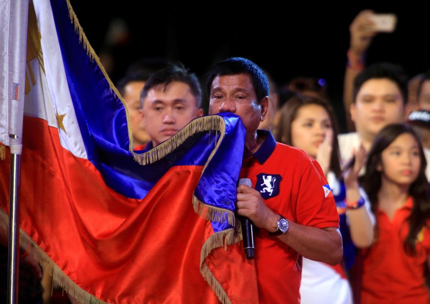 Philippine presidential candidate and Davao city mayor Rodrigo 'Digong' Duterte kisses the Philippine flag during a 