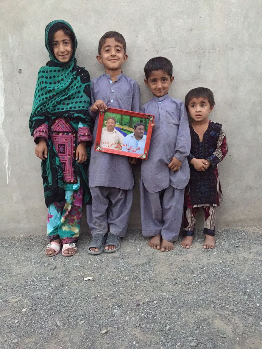 The children of Mohammad Azam, a Pakistani driver who was killed alongside Afghan Taliban's slain chief Mullah Akthar Mansour in a US drone strike, hold a photograph of their father outside the house of their uncle Mohammad Qasim in the Pakistan-Iran border town of Taftan on May 30, 2016. The brother of a man who was killed alongside the Taliban's slain chief Mullah Akthar Mansour in an American drone strike in southwest Pakistan is pressing murder and terrorism charges against US officials, police said on May 30. Mansour was travelling by car near the town of Ahmad Wal on May 21 when he was killed, a major blow to the Islamist group that has been waging a guerilla war in Afghanistan since being toppled from power in 2001. / AFP / ALI RAZA