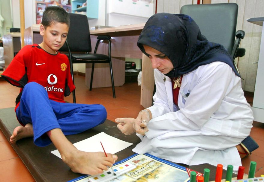 Ali Ismail Abbas (L), 12, is guided by therapist Nafisa Kamal at the Ibn Sina hospital in Kuwait City 08 June 2003. Abbas lost both arms and received major burns in coalition bombing in Baghdad 30 March 2003 that claimed most of his family. Kuwait has received a number of injured Iraqi children for treatment.  AFP PHOTO/Yasser AL-ZAYYATOPSE_2003JUN11_IRAQ_NINO SIN BRAZOS_VICTIMA _GUERRA_ALI ABBAS_HERIDO_HOSPITAL_RECUPERACION2003JUN11_AFD