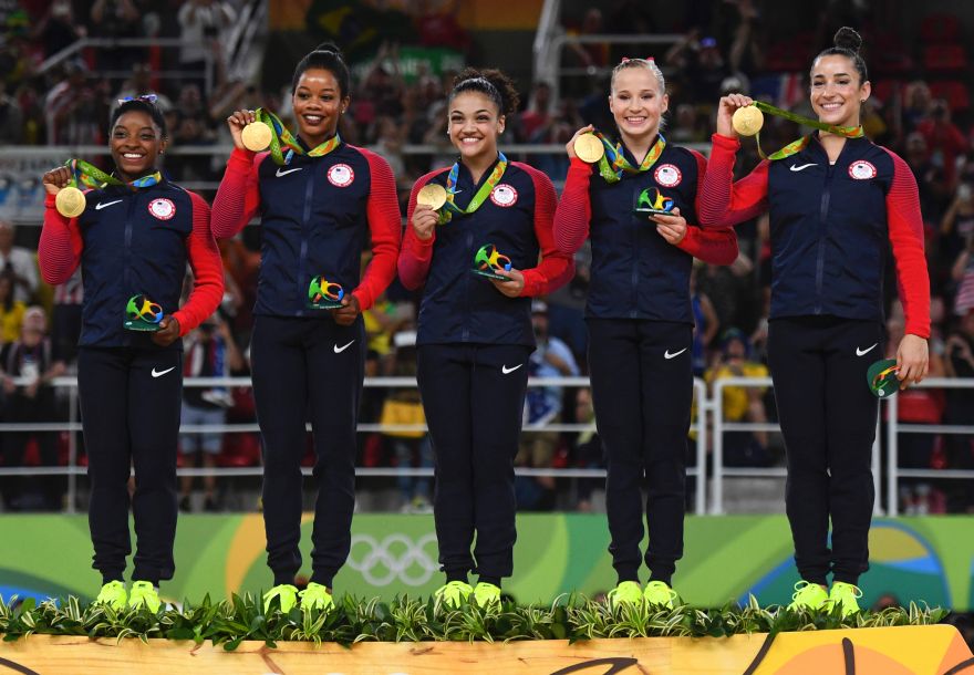 (R-L) US gymnasts Alexandra Raisman, Madison Kocian, Lauren Hernandez, Gabrielle Douglas and Simone Biles celebrate with their gold medals on the podium during the women's team final Artistic Gymnastics at the Olympic Arena during the Rio 2016 Olympic Games in Rio de Janeiro on August 9, 2016.  / AFP / Ben STANSALL